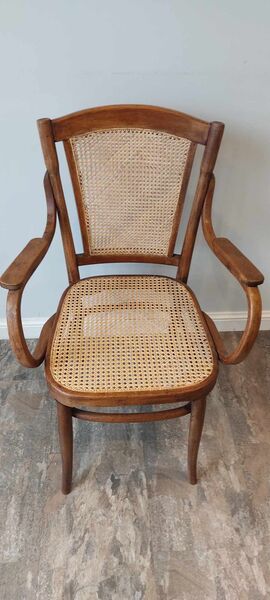Thonet-style bentwood armchair with hand-caned seat and back panel — front view showing full cane weave