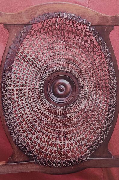 Circular medallion chair back with worn and broken sunburst spoke caning — before restoration