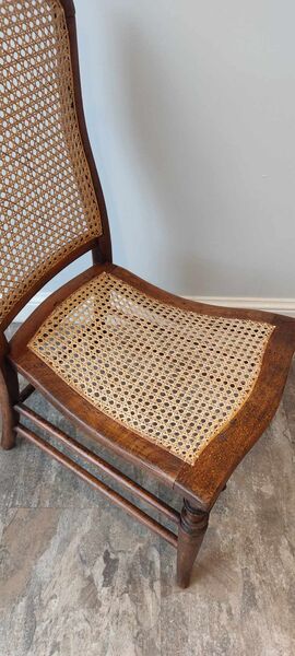 Close-up detail of hand-caned seat and back panel on a Victorian walnut side chair