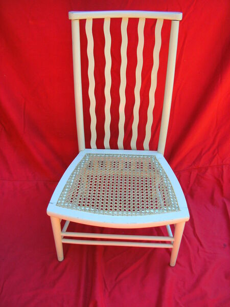 White-painted wavy spindle-back chair with freshly hand-caned seat — after restoration